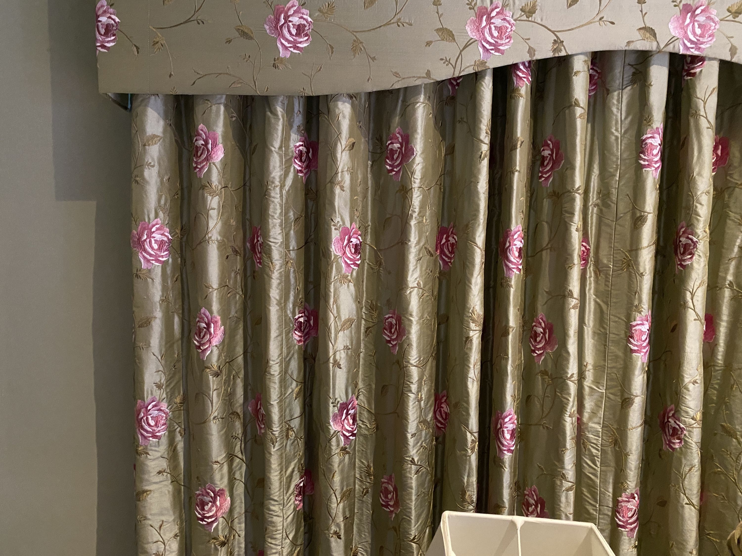 A pair of embroidered woven silk curtains, with pelmet, decorated with pink roses on a eau de nil ground, drop 2.3m, made to generously fit an aperture of 4m width